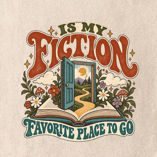 Close-up of the “FICTION / IS MY / FAVORITE PLACE TO GO” T-shirt design, showing an open book, a teal doorway leading to a winding path and cottage, flowers, mushrooms and stars.