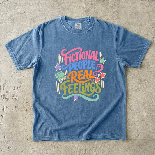 Blue Jean Comfort Colors bookish T-shirt featuring colourful Fictional People, Real Feelings typography with book and heart details.