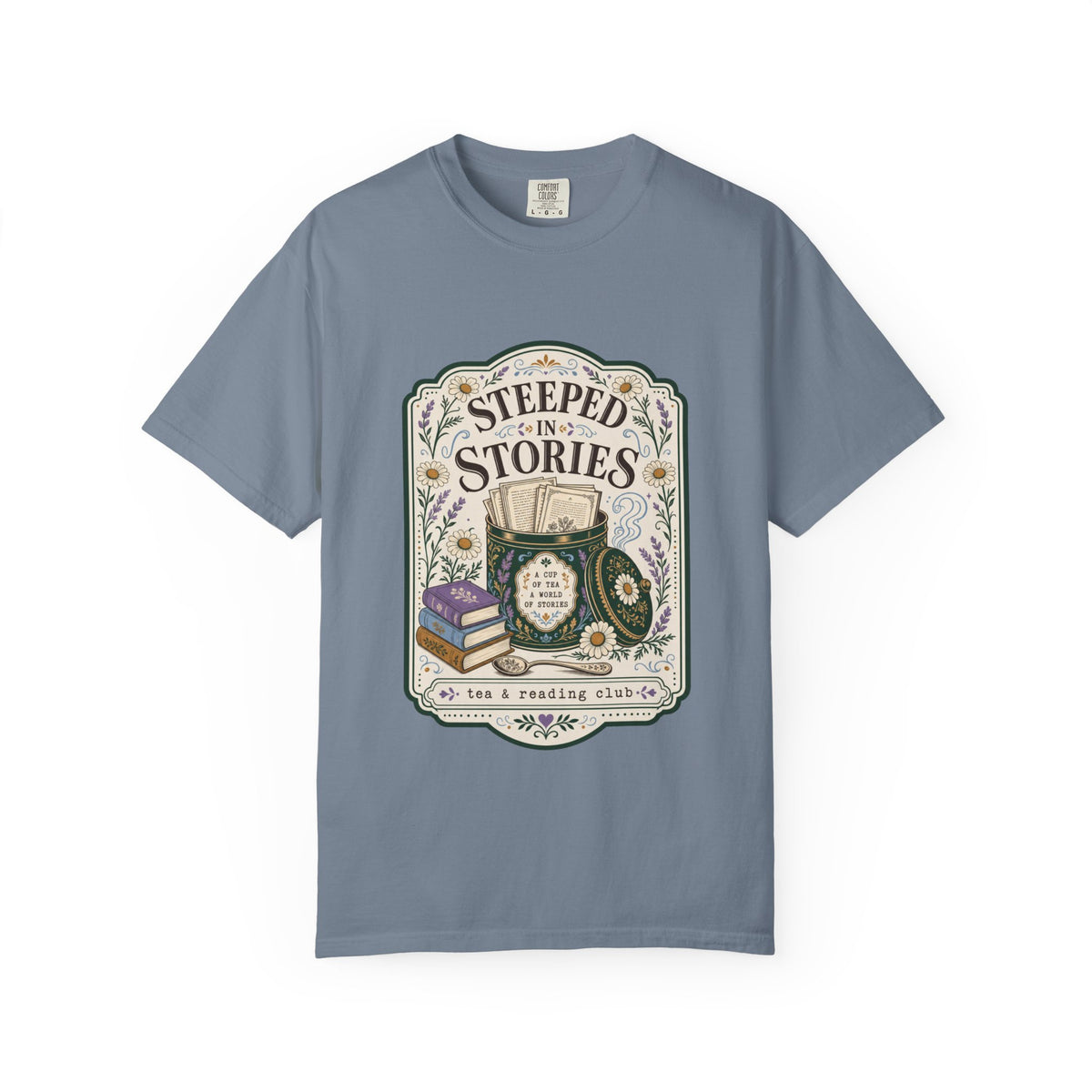Steeped in Stories tea and reading club T-shirt featuring books, a floral tea tin, daisies and lavender on Blue Jean.
