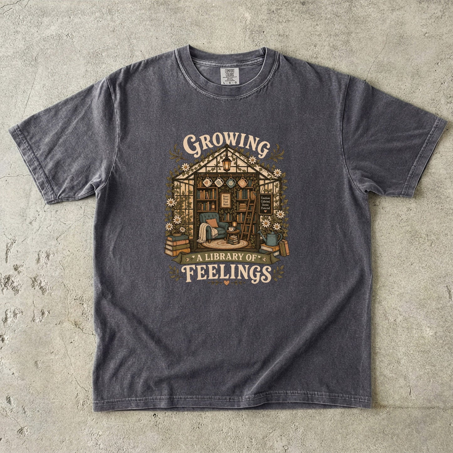 Growing a Library of Feelings Book Lover Shirt on a Pepper Comfort Colors T-shirt featuring a cosy greenhouse library illustration.

