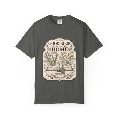 A Good Book Feels Like Home book lover T-shirt with open book, lavender, rosemary, chamomile and daisy botanical design on pepper.

