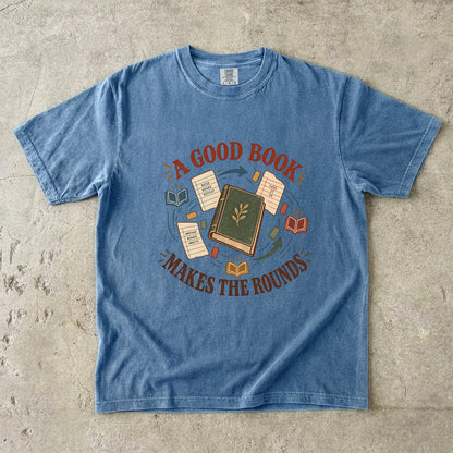 Blue Jean book lover T-shirt with “A Good Book Makes the Rounds,” a book, arrows and sharing notes
