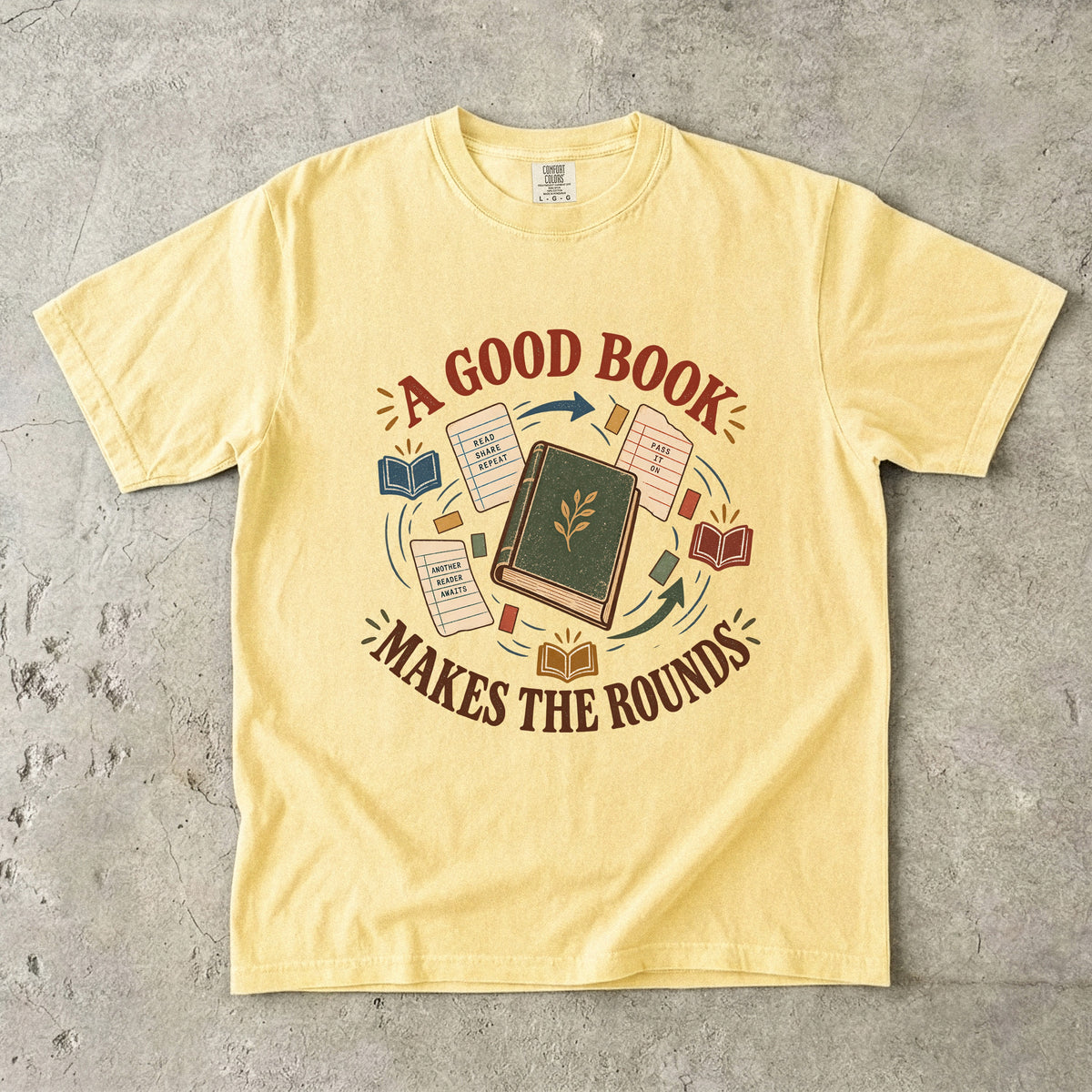 Butter book lover T-shirt with “A Good Book Makes the Rounds,” a book, arrows and sharing notes