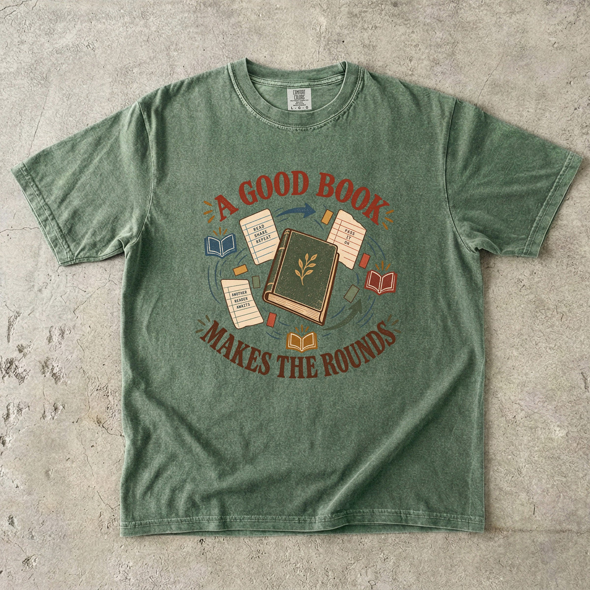 Moss book lover T-shirt with “A Good Book Makes the Rounds,” a book, arrows and sharing notes