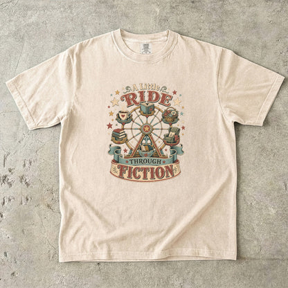 Front view of an Ivory Comfort Colors book lover shirt featuring the "A Little Ride Through Fiction" vintage literary illustration with books, flowers and cozy reading details.