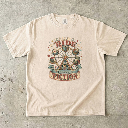 Front view of an Ivory Comfort Colors book lover shirt featuring the "A Little Ride Through Fiction" vintage literary illustration with books, flowers and cozy reading details.