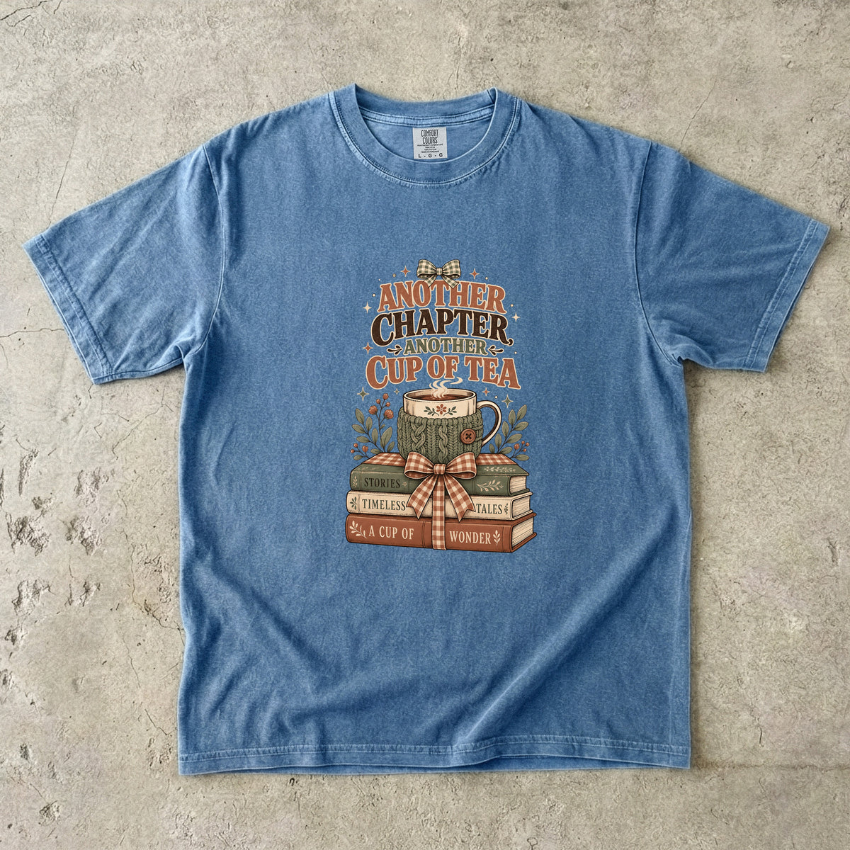 Another Chapter Another Cup of Tea reading shirt in Blue Jean with vintage books, teacup and cozy reading artwork.