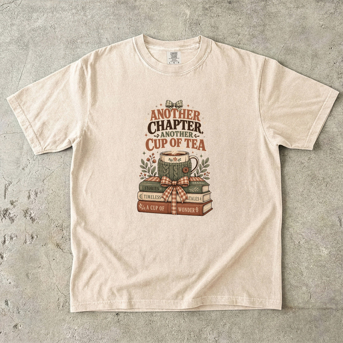 Another Chapter Another Cup of Tea reading shirt in Ivory with a cozy floral teacup, stacked books and leafy details.