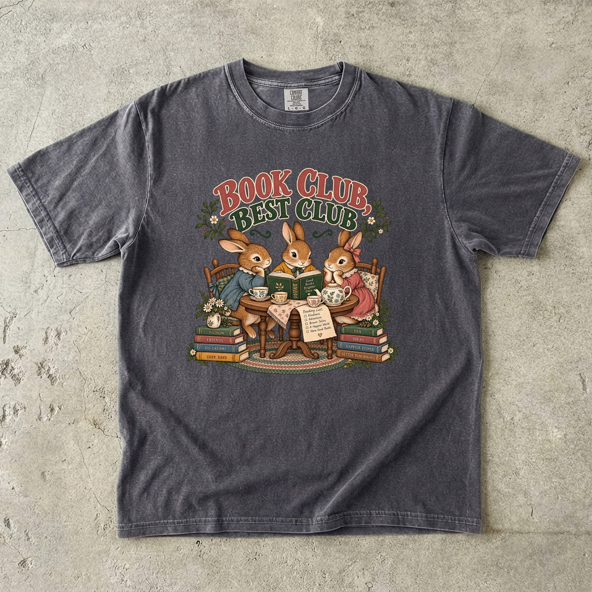 Pepper T-shirt featuring “Book Club, Best Club” with three rabbits reading together at a tea table, floral china, books and daisies.