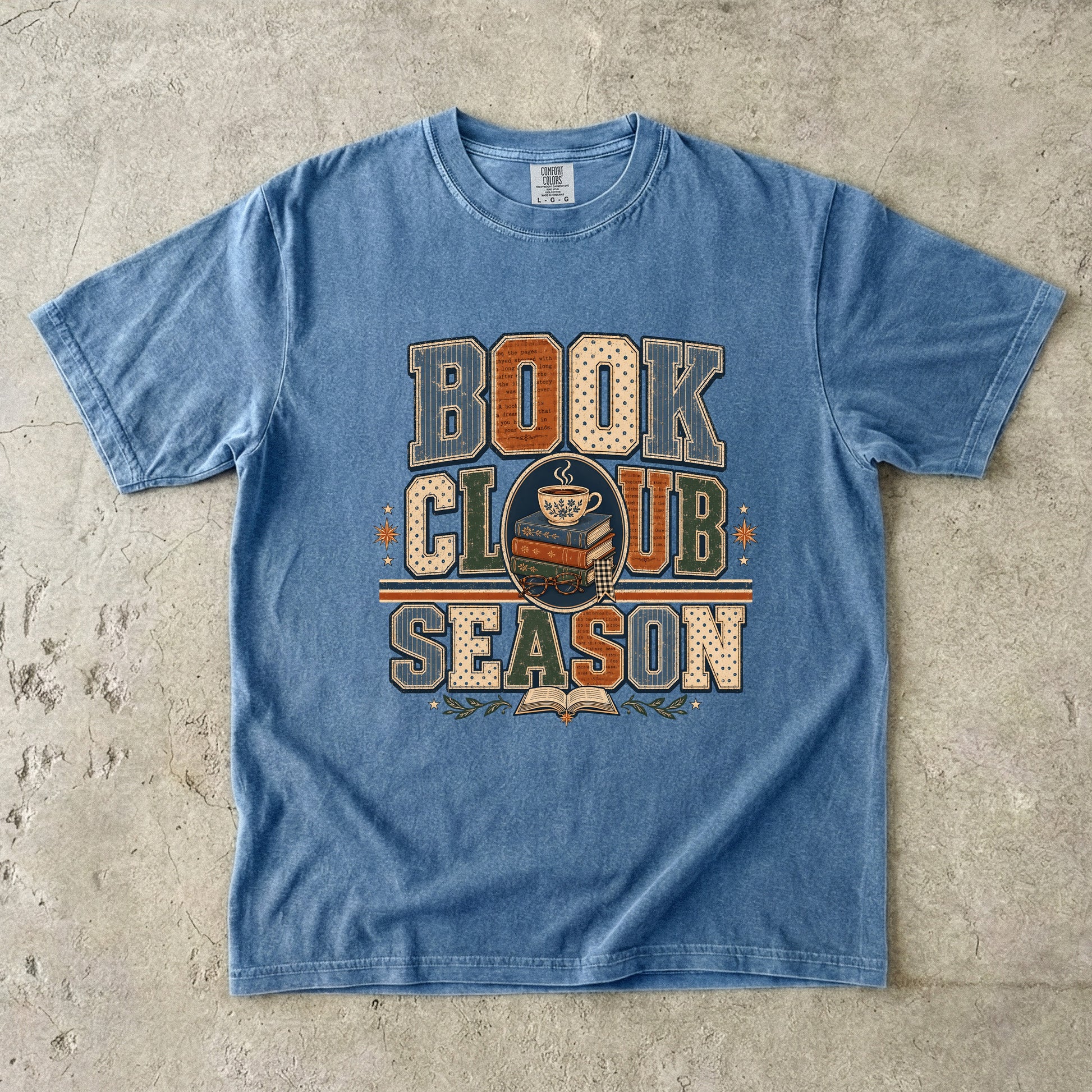 Blue Jean Comfort Colors Book Club Season T-shirt featuring vintage collegiate lettering, stacked books and a teacup.
