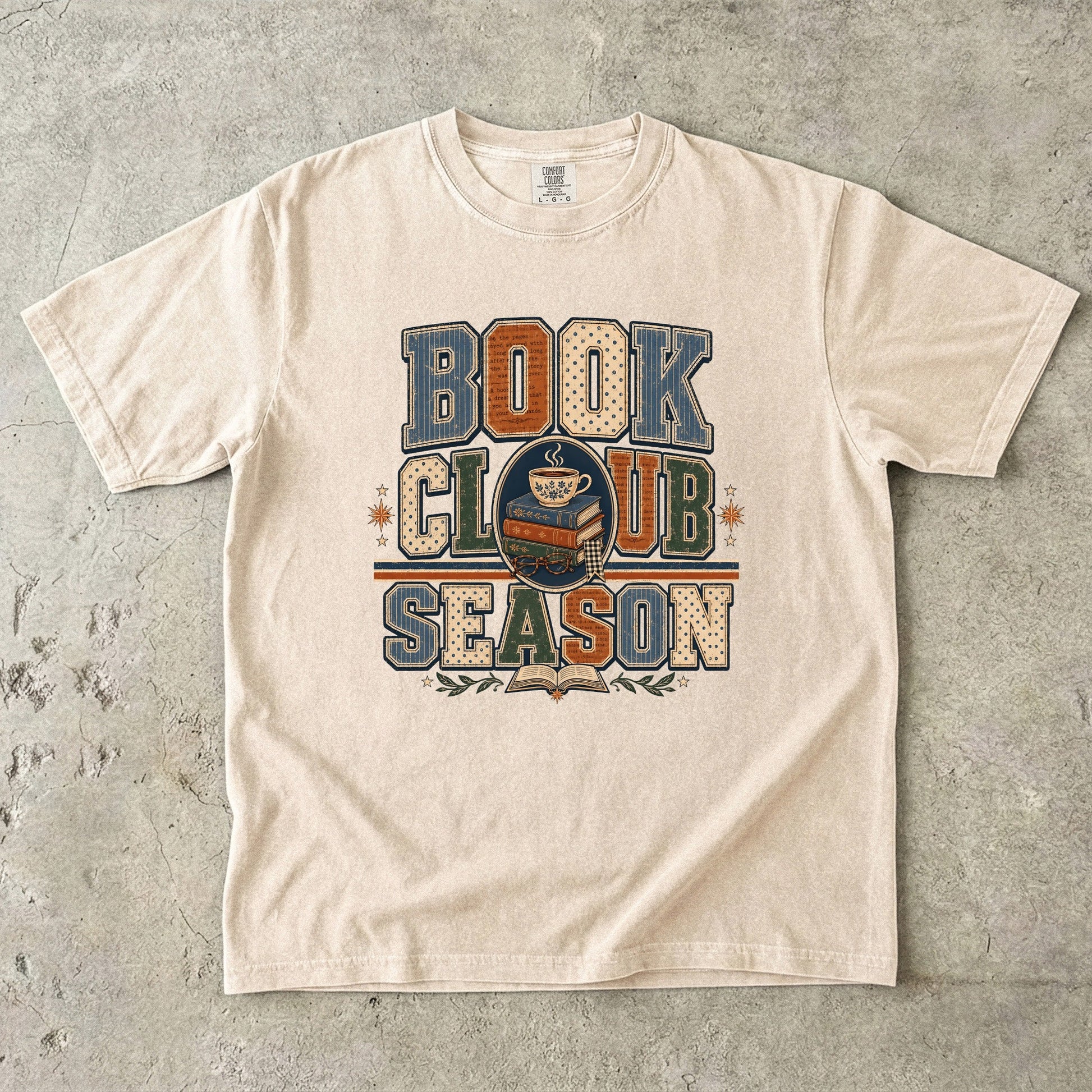 Ivory Comfort Colors Book Club Season T-shirt with retro varsity lettering, books and a cozy cup of tea.