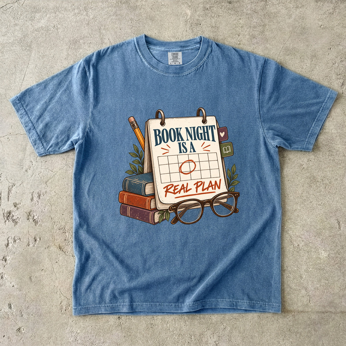 Blue Jean reading T-shirt with “Book Night Is a Real Plan” on a marked calendar beside books and glasses