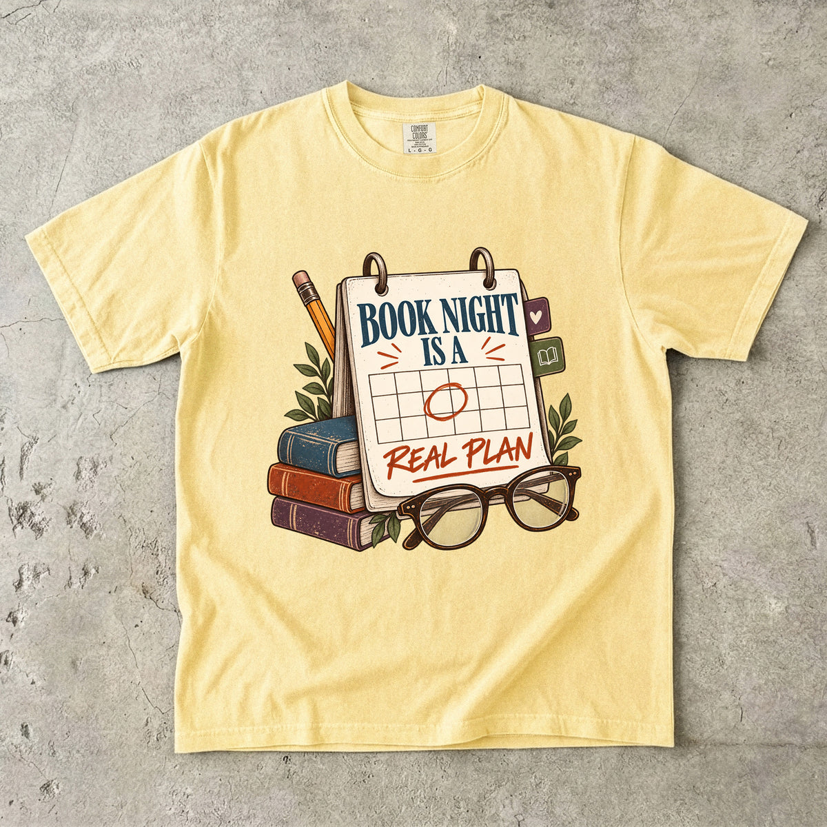 Butter reading T-shirt with “Book Night Is a Real Plan” on a marked calendar beside books and glasses