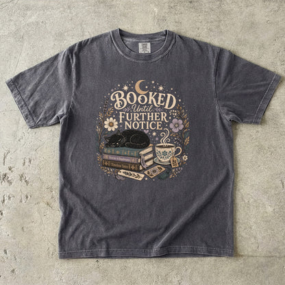 Booked Until Further Notice cat reading T-shirt with sleeping black cat, stacked books, teacup and flowers on Pepper.