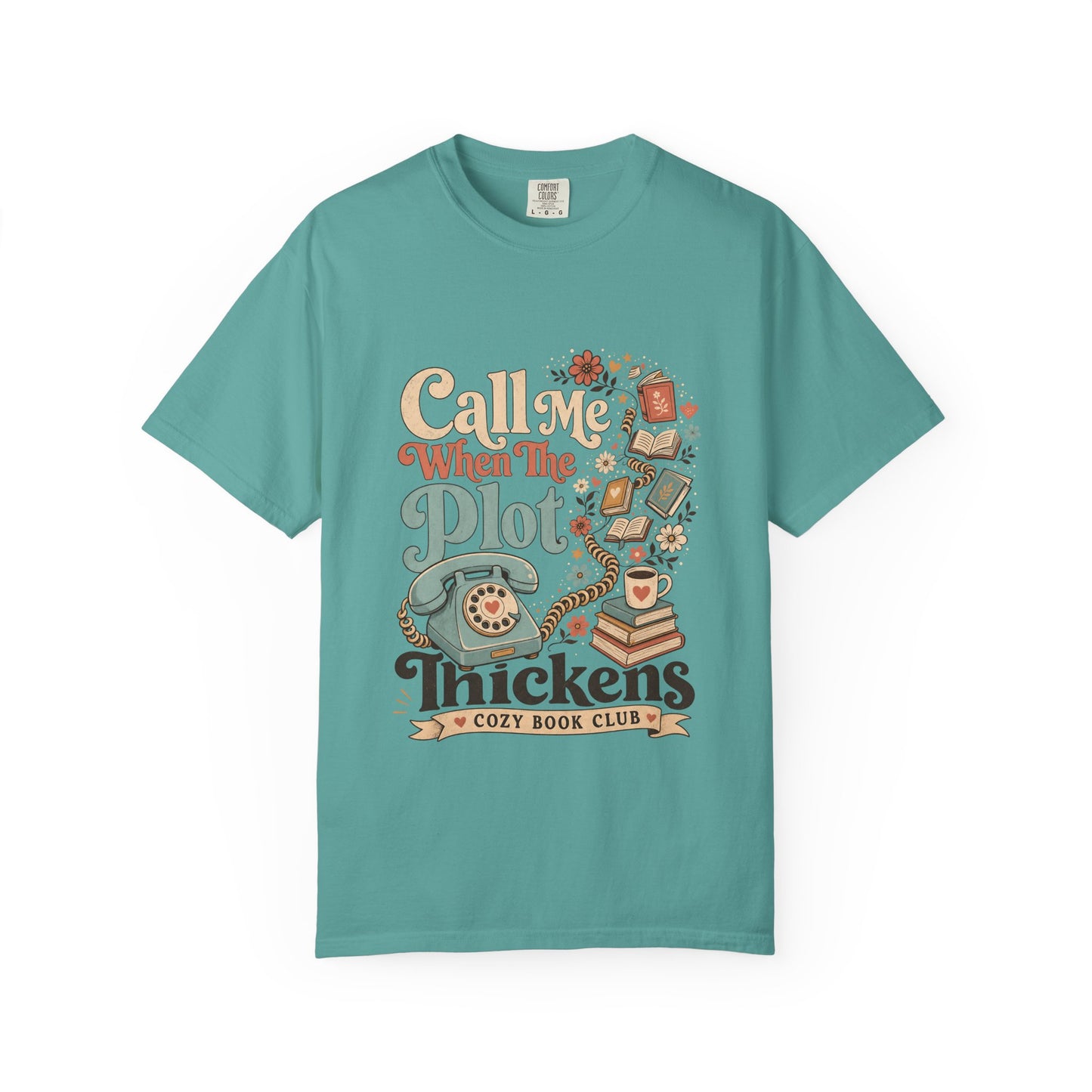 Front view of the Call Me When The Plot Thickens Book Lover Shirt on a Seafoam Comfort Colors T-shirt with vintage books, rotary telephone and cozy reading artwork.