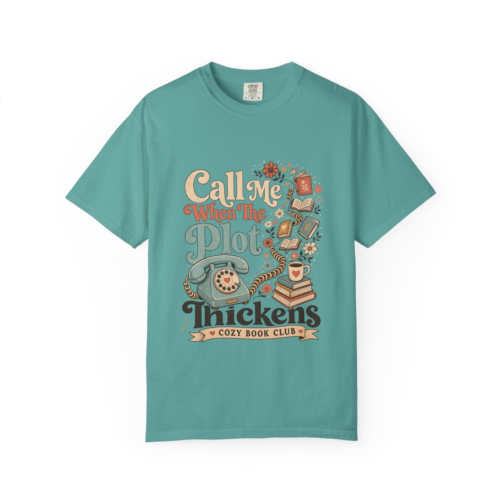 Front view of the Call Me When The Plot Thickens Book Lover Shirt on a Seafoam Comfort Colors T-shirt with vintage books, rotary telephone and cozy reading artwork.