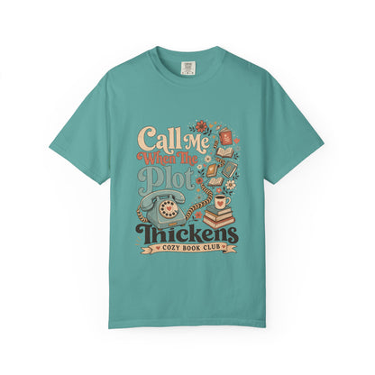 Front view of the Call Me When The Plot Thickens Book Lover Shirt on a Seafoam Comfort Colors T-shirt with vintage books, rotary telephone and cozy reading artwork.