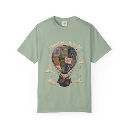 Front view of the Carried Away By Stories reading shirt on a Bay Comfort Colors 1717 T-shirt featuring a whimsical book hot air balloon with vintage storybook illustrations.