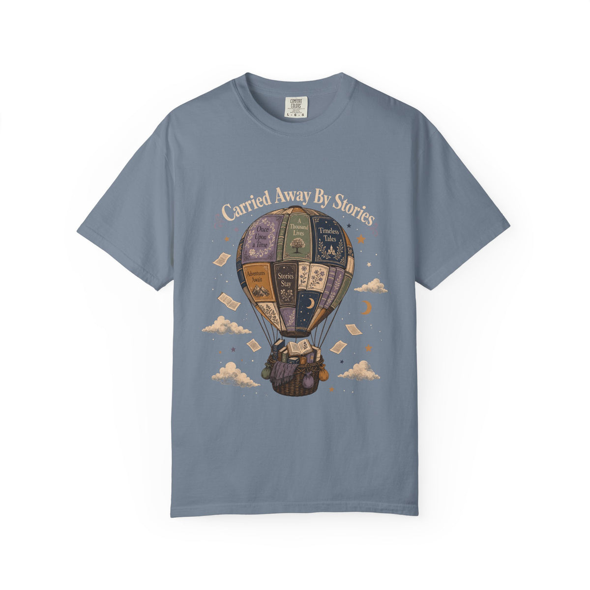Carried Away by Stories book lover T-shirt in Blue Jean featuring a hot air balloon made from books with floating pages and clouds