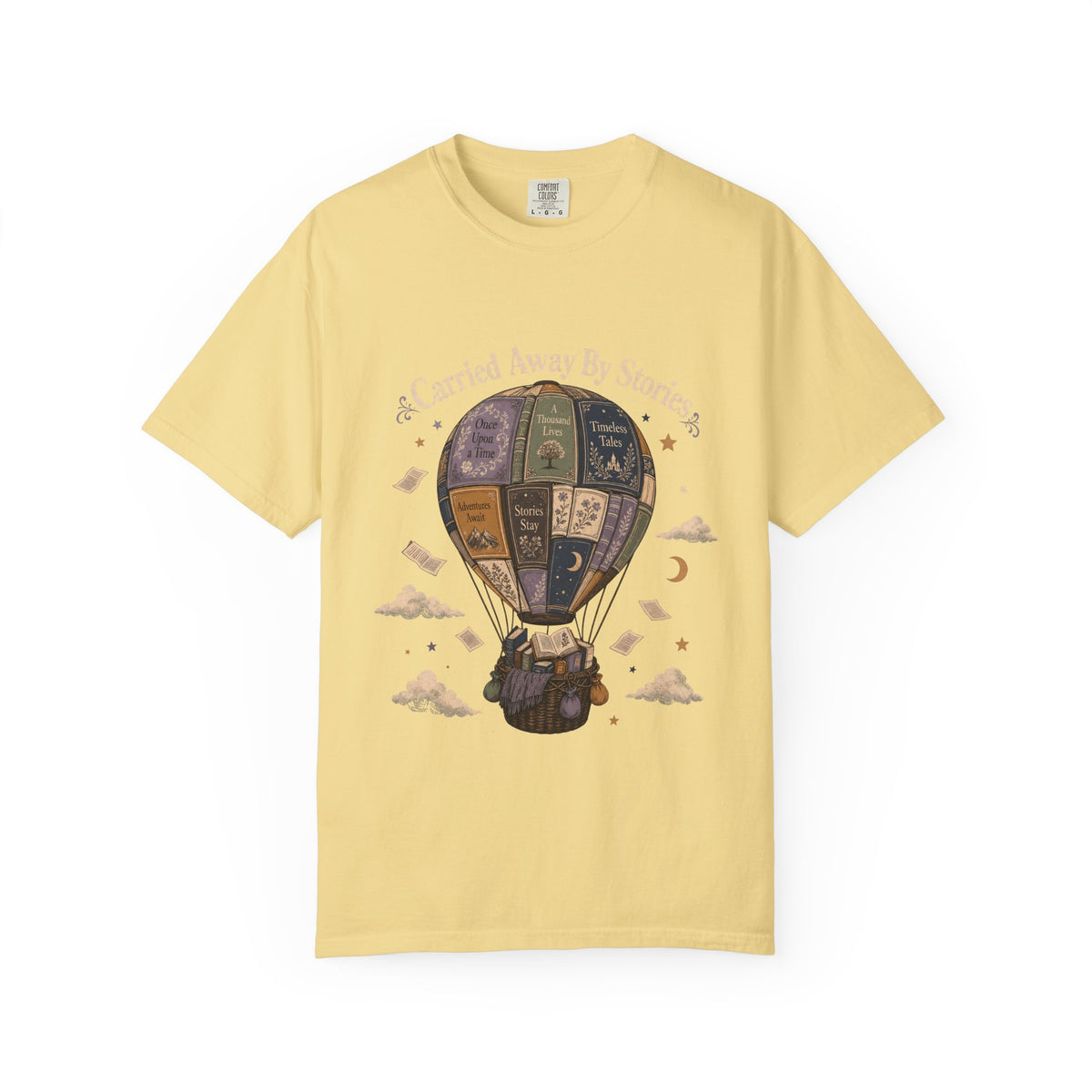 Carried Away by Stories book lover T-shirt in Butter featuring a hot air balloon made from books with floating pages and clouds