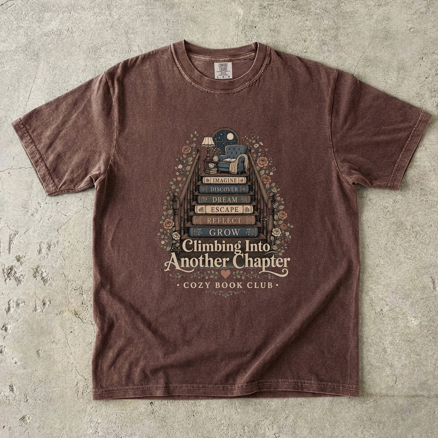 Front view of an Espresso Comfort Colors® book lover T-shirt featuring the Climbing Into Another Chapter vintage literary illustration with book stairs, flowers and a cozy reading nook.