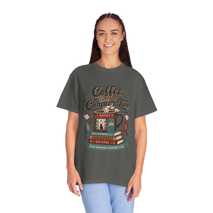 Woman wearing the Coffee Before Chapter Two Pepper Comfort Colors coffee lover and book lover T-shirt featuring a cozy bookstore and coffee illustration.