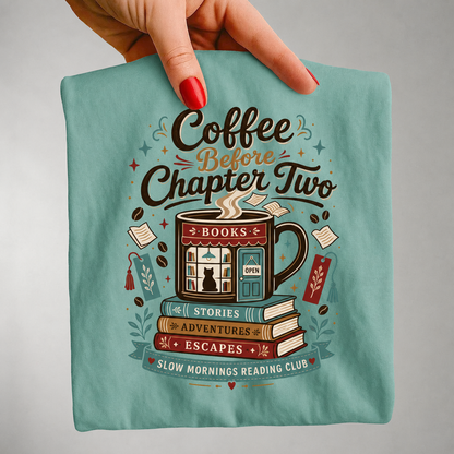 Close-up handheld view of the Coffee Before Chapter Two seafoam 
Comfort Colors coffee lover and book lover T-shirt showing the detailed bookstore artwork.