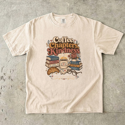 Coffee, Chapters, Kindness cozy reader T-shirt with coffee, books and croissant design on Ivory.