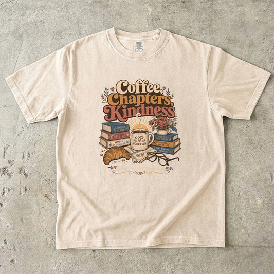 Coffee, Chapters, Kindness cozy reader T-shirt with coffee, books and croissant design on Ivory.