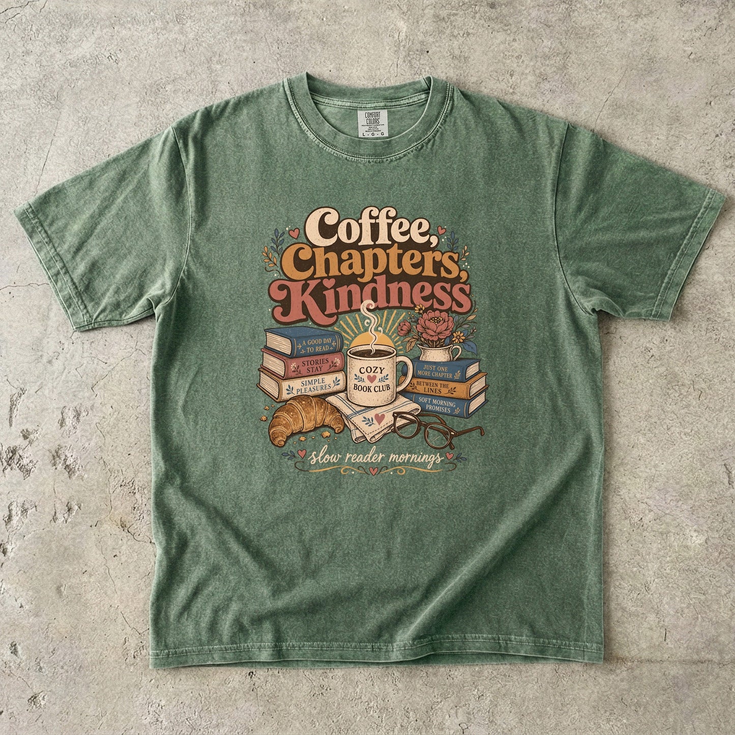 Coffee, Chapters, Kindness cozy reader T-shirt with coffee, books and croissant design on Moss.