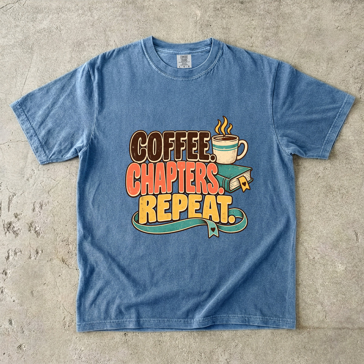 Blue Jean T-shirt featuring “Coffee. Chapters. Repeat.” with brown, coral and gold lettering, a steaming mug, a teal book and heart-shaped bookmark details.