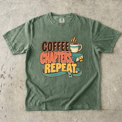 Moss T-shirt featuring “Coffee. Chapters. Repeat.” with brown, coral and gold lettering, a steaming mug, a teal book and heart-shaped bookmark details.