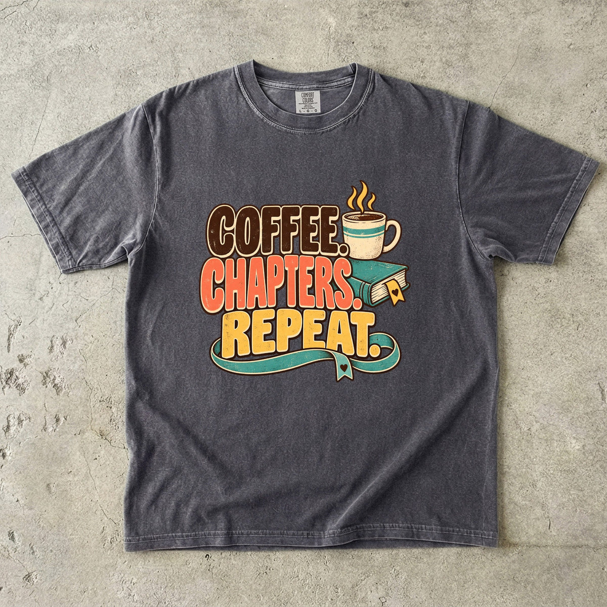 Pepper T-shirt featuring “Coffee. Chapters. Repeat.” with brown, coral and gold lettering, a steaming mug, a teal book and heart-shaped bookmark details.