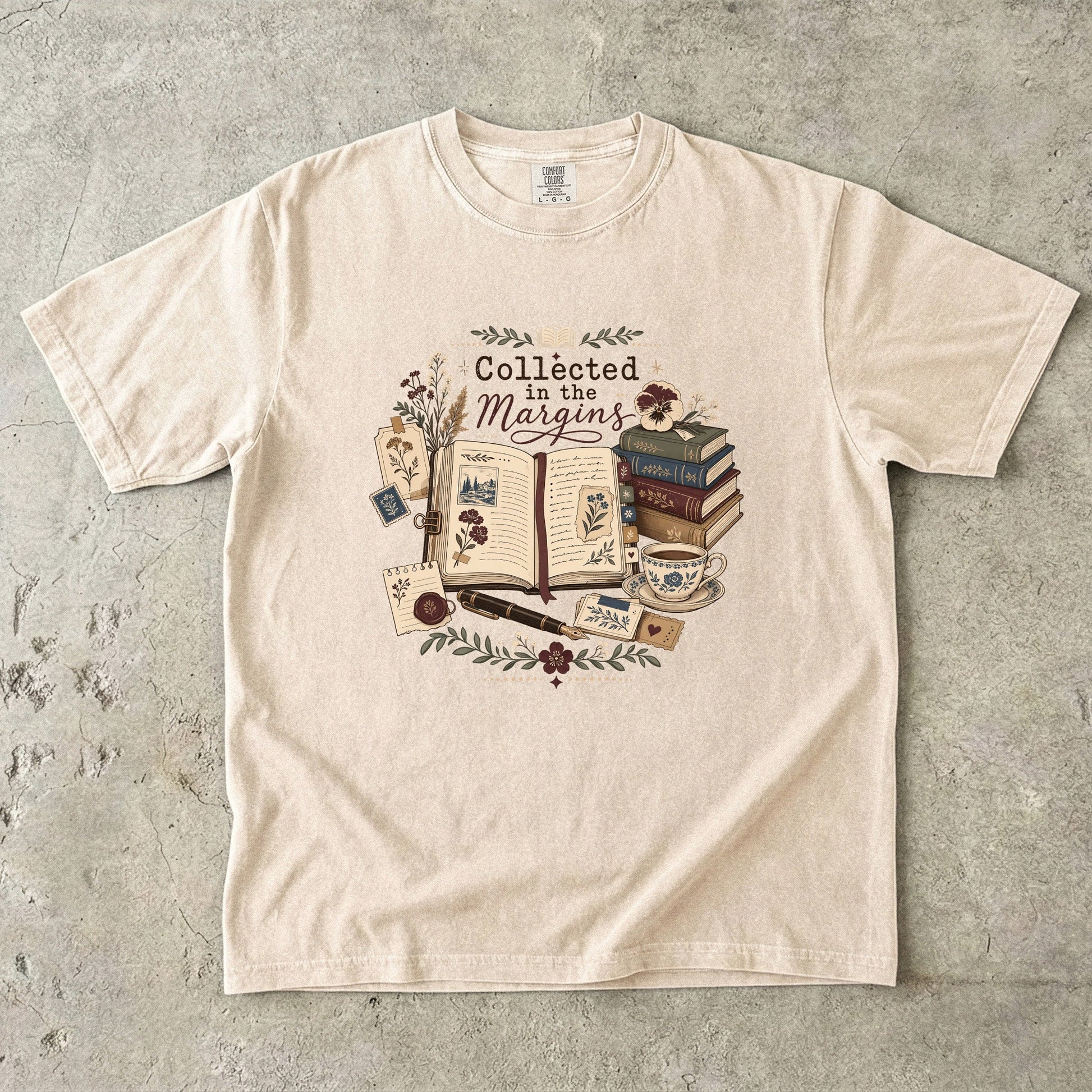 Collected in the Margins literary T-shirt with annotated open book, pressed flowers and notes on Ivory.