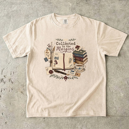 Collected in the Margins literary T-shirt with annotated open book, pressed flowers and notes on Ivory.