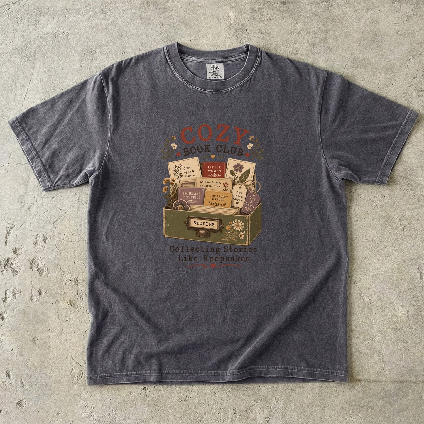 Cozy Book Club T-shirt in Pepper featuring a vintage story collection with classic books, flowers and reading notes