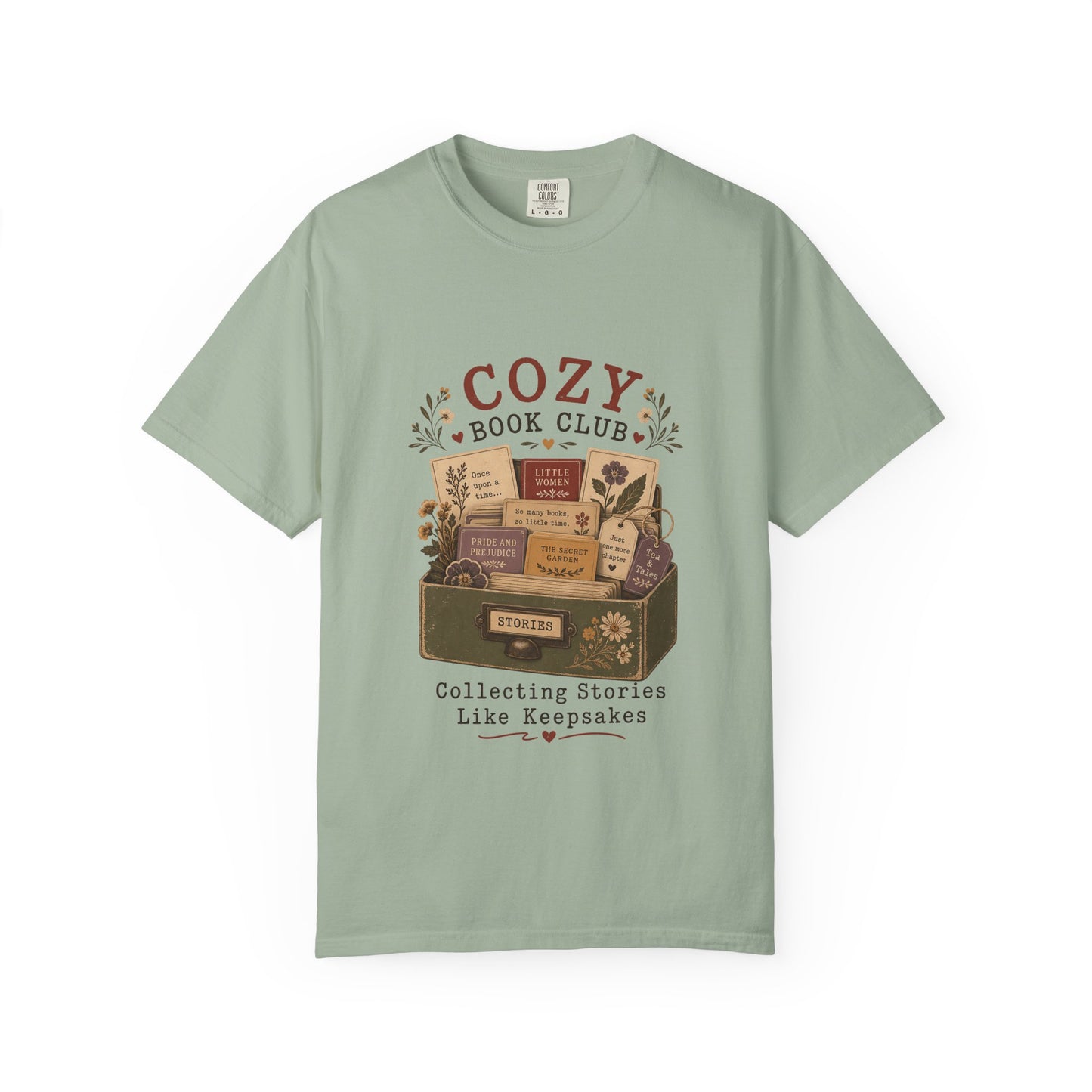 Front view of the Cozy Book Club Comfort Colors T-shirt in Bay featuring a vintage-inspired illustration of classic books in a library drawer.


