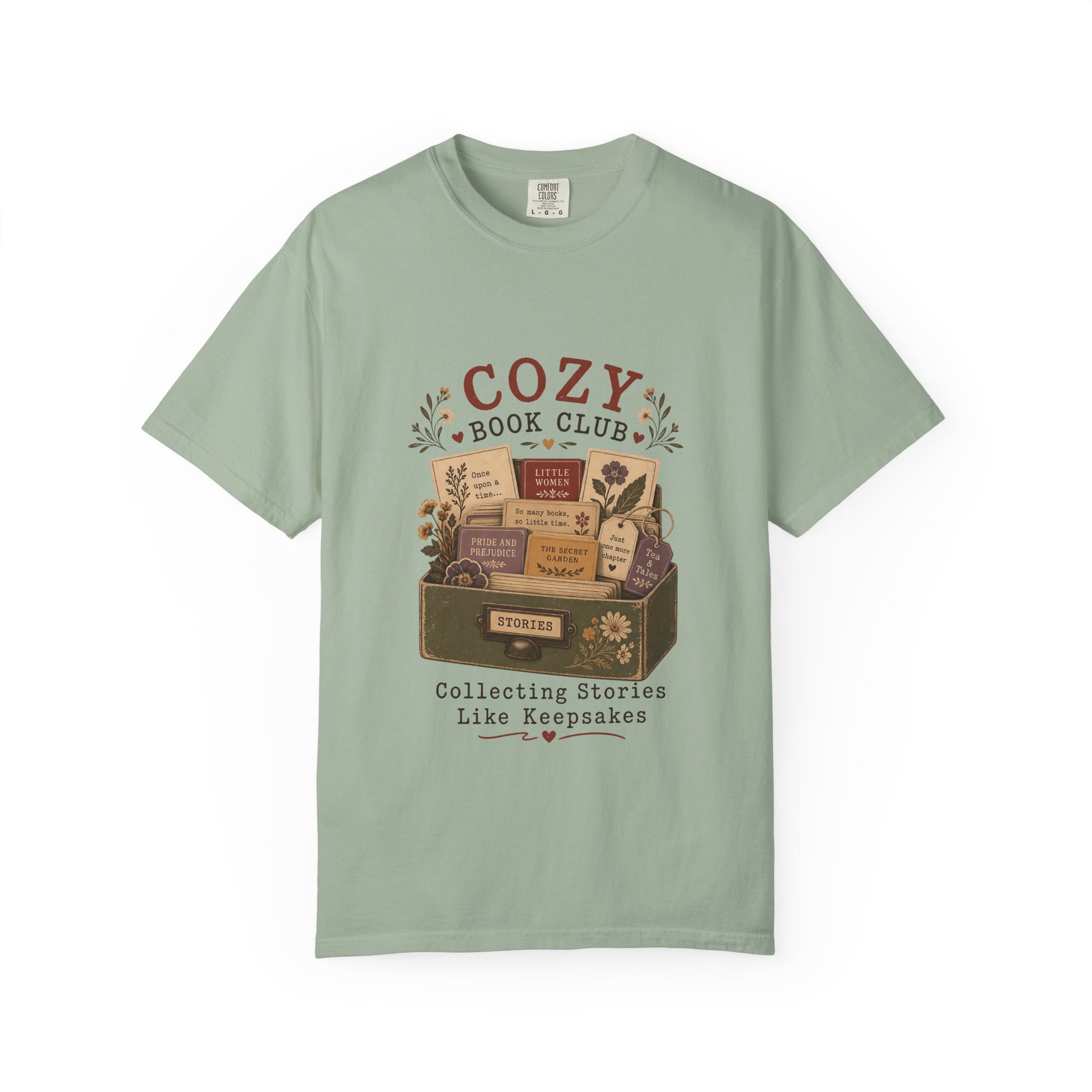 Front view of the Cozy Book Club Comfort Colors T-shirt in Bay featuring a vintage-inspired illustration of classic books in a library drawer.

