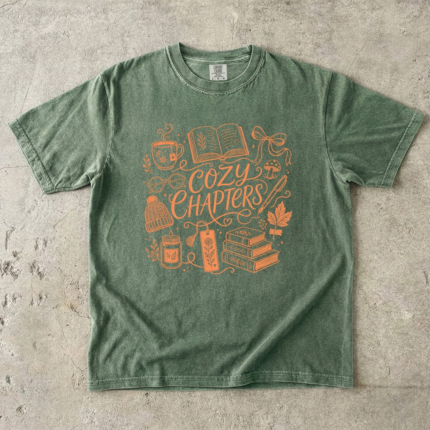 Moss Comfort Colors bookish T-shirt featuring the Cozy Chapters line art design with books and cozy reading essentials.