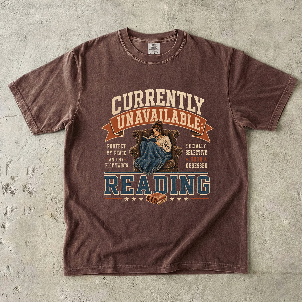 Espresso reading T-shirt featuring Currently Unavailable: Reading with a reader curled in a leather armchair beneath a blanket with a book.