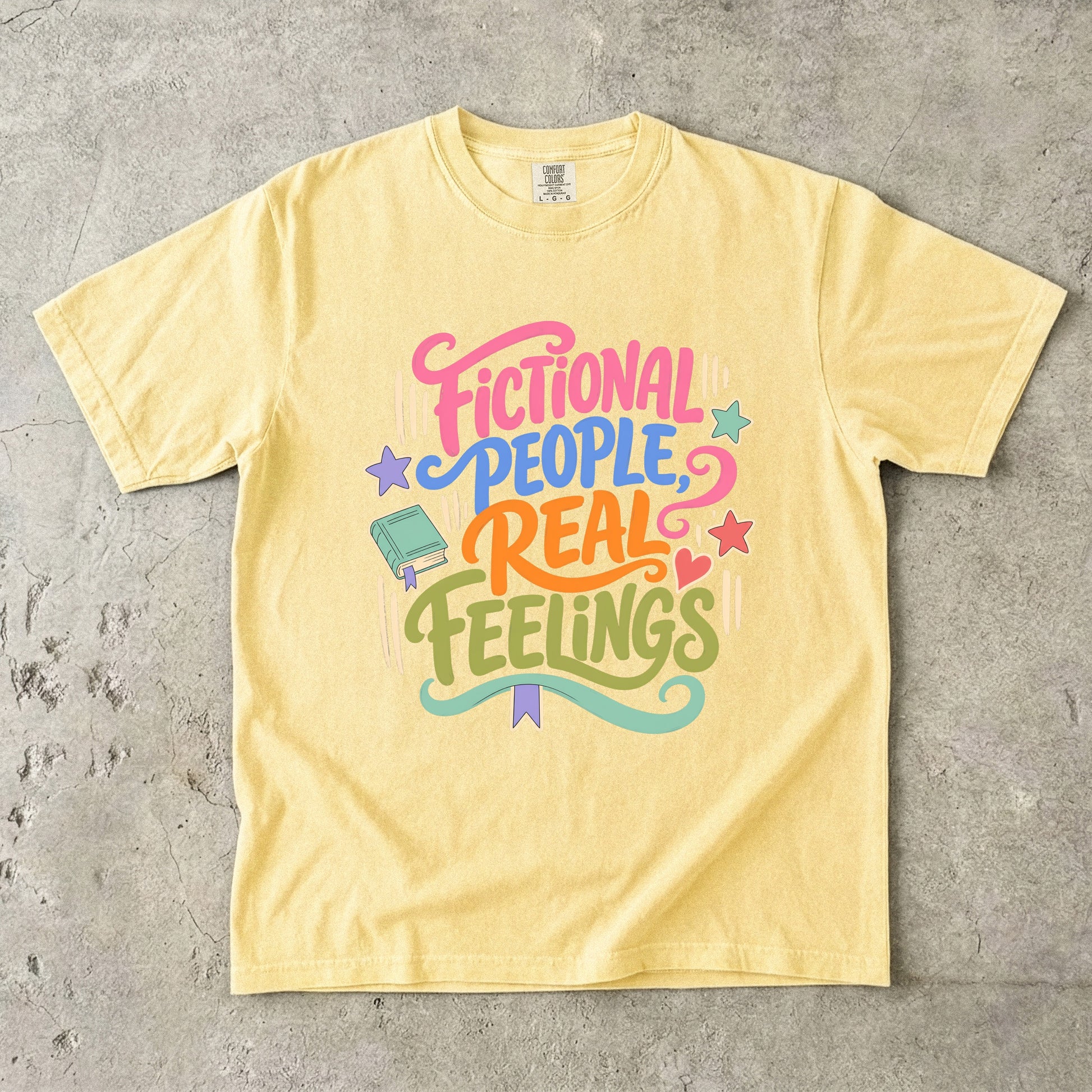 Butter Comfort Colors book lover shirt featuring colourful Fictional People, Real Feelings typography and bookish details.