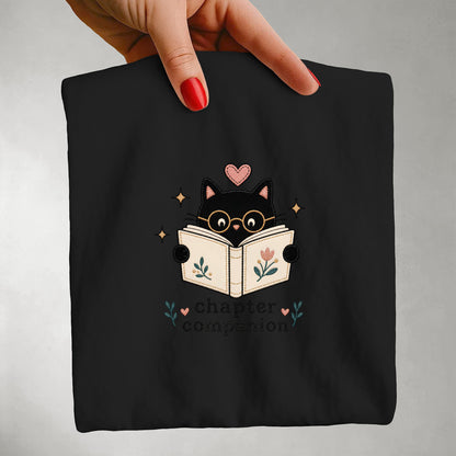 Close-up of the Chapter Companion vintage cat illustration printed on a black Comfort Colors® graphic T-shirt.