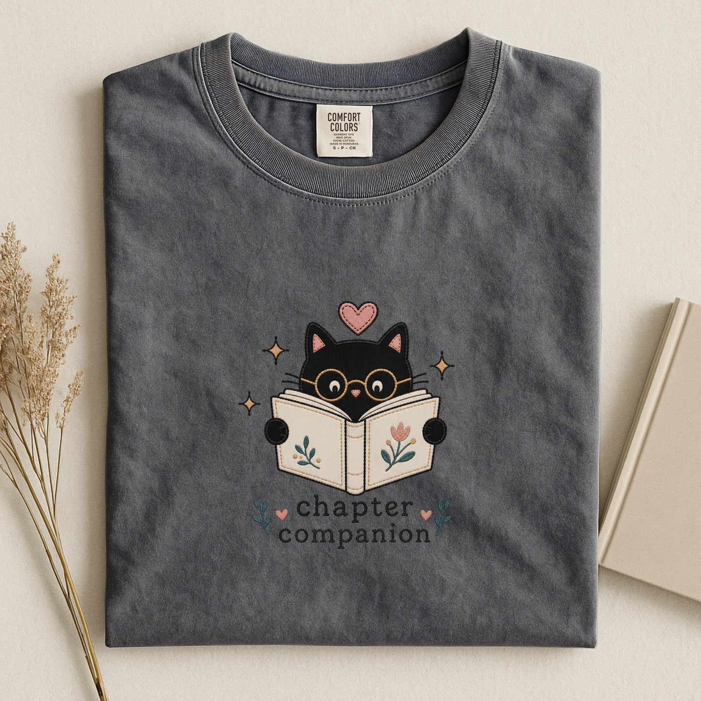 Front view of the pepper Chapter Companion Comfort Colors® book lover cat T-shirt by Flourish Creation Labs.