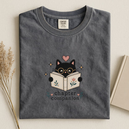 Front view of the pepper Chapter Companion Comfort Colors® book lover cat T-shirt by Flourish Creation Labs.