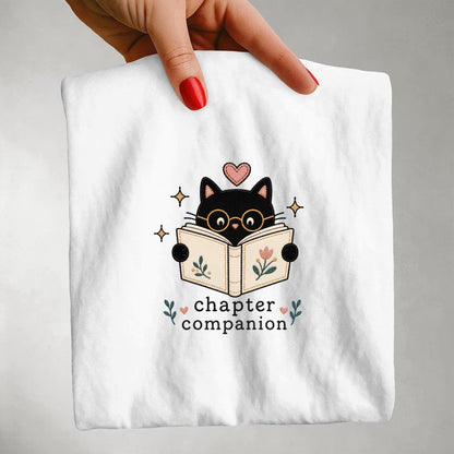 Front view of the white Chapter Companion book lover cat T-shirt by Flourish Creation Labs printed on a Comfort Colors® garment-dyed T-shirt.