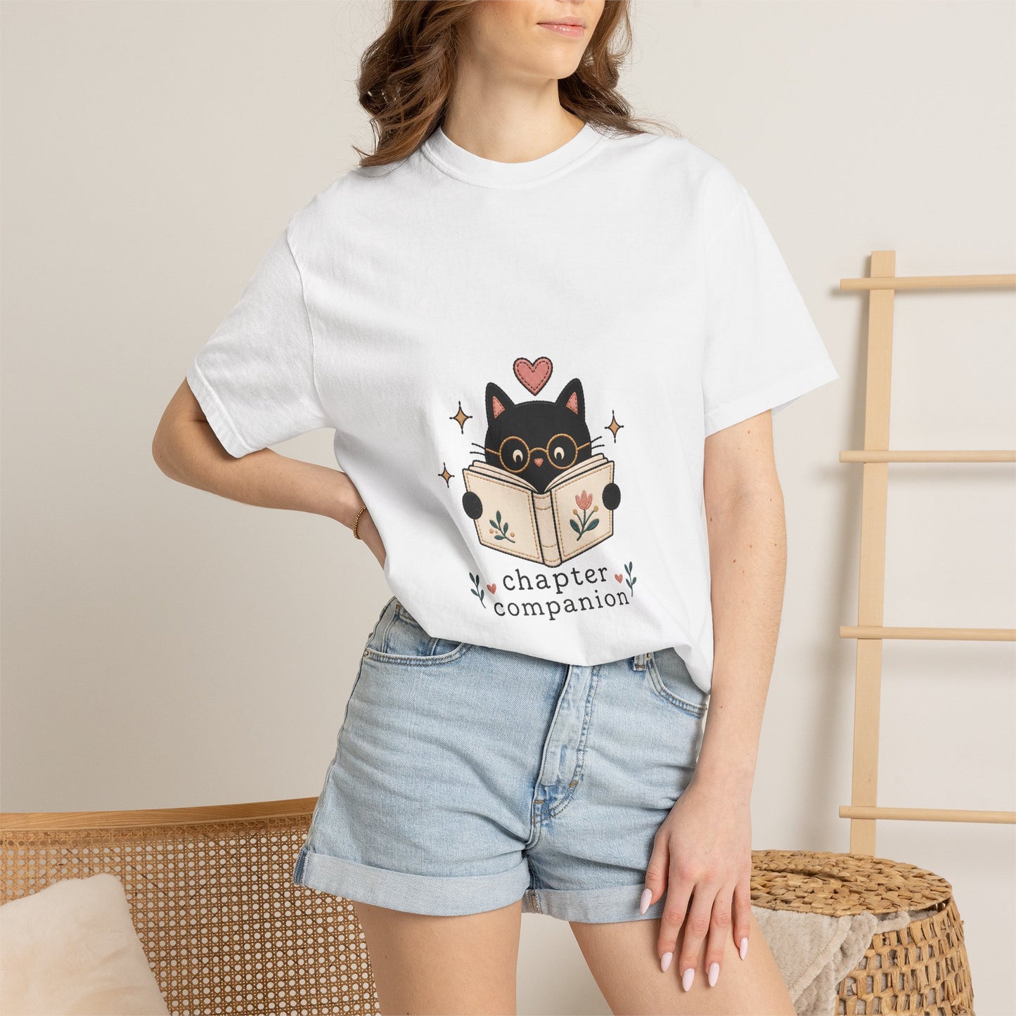 Woman wearing the white Chapter Companion book lover cat T-shirt by Flourish Creation Labs, styled as a relaxed everyday outfit for readers and book lovers.