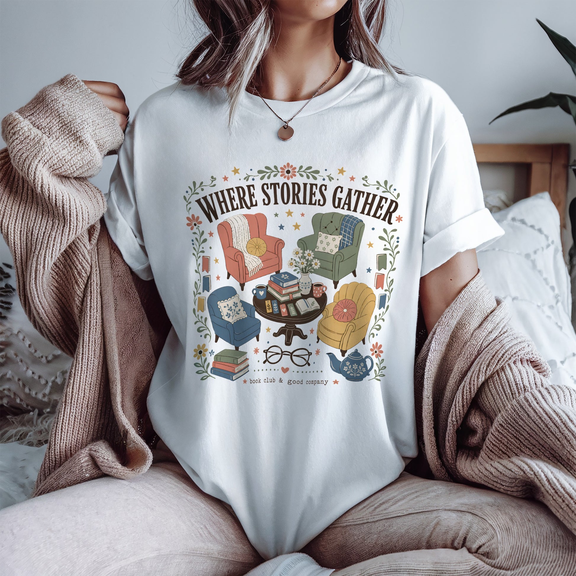 Woman wearing the Where Stories Gather vintage book lover T-shirt in white by Flourish Creation Labs, celebrating libraries, cosy reading and the joy of discovering new stories.