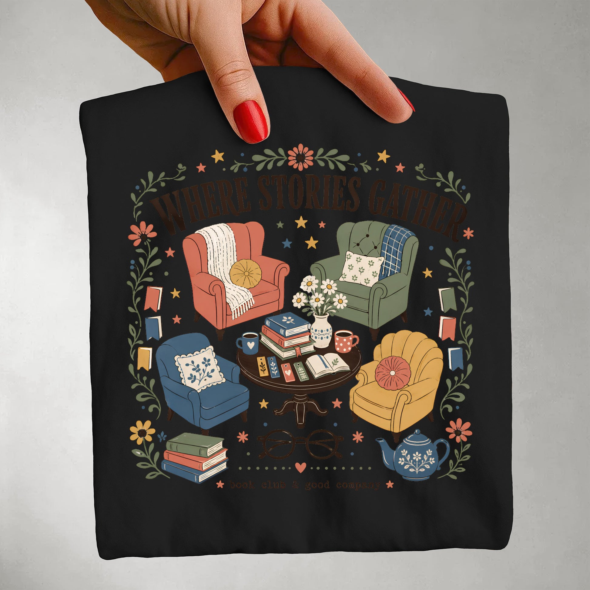 Close-up of the Where Stories Gather literary artwork featuring books, reading and community on a black Comfort Colors® T-shirt.