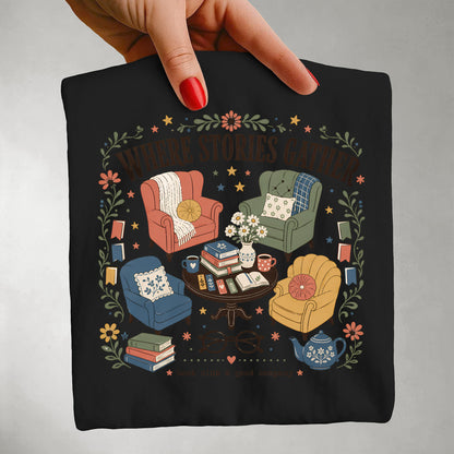 Close-up of the Where Stories Gather literary artwork featuring books, reading and community on a black Comfort Colors® T-shirt.