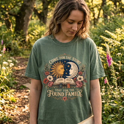 Woman wearing a Moss Comfort Colors found family book lover T-shirt with vintage celestial and floral artwork.